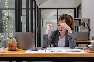 Stressed business woman working from home on laptop looking worried, tired and overwhelmed.