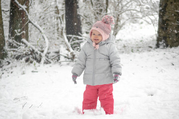 Fototapeta na wymiar Joyful child in snow in forest