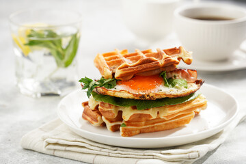 Savory breakfast - fresh homemade belgian waffle sandwich with green lettuce, crisp bacon and fried...