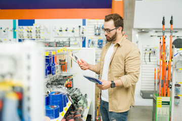 Smart man making a decision to buy products at the hardware store