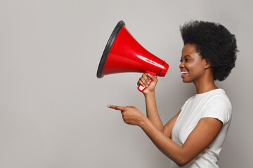 Happy black woman holding red loudspeaker. Leadership, attention, advertisement, broadcasting and sound concept