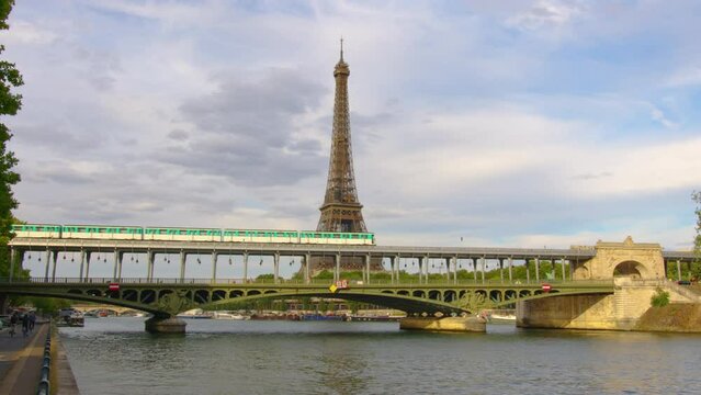 Iron bridge over the river in Paris near the metal tower on which the Paris metro passes. Metro train over Bir-Hakeim bridge and the Eiffel Tower