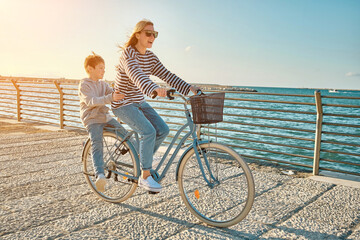 Happy family, Carefree mother and son with bike riding on beach having fun, on the seaside...