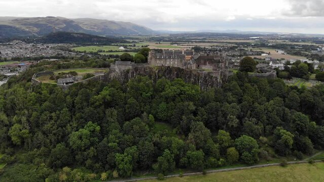 Aerial drone footage of Stirling Castle in Scotland with the Wallace monument in the distant background.