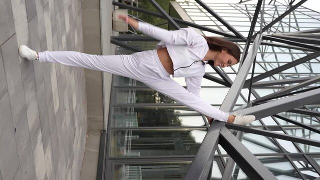 Young asian woman showing a perfect flexibility at the city street.