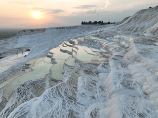 Pamukkale Travertines Cinematic Aerial Drone footage. Turkish famous white thermal bath with healthy clean water in a beautiful sunset. 