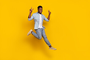 Full length photo of cheerful guy jump high make v sign friendly greeting isolated vibrant color background