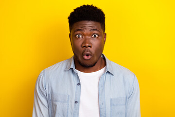 Photo of impressed millennial brunet man look camera wear jeans shirt isolated on yellow color background