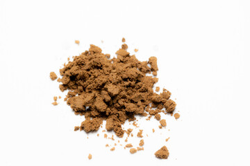 heap of brown powder on white background. powdered herbs or dietary supplements or cocoa. dry tobacco powder 
