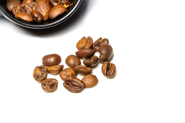 heap of rosted coffee beans on a white background with a plastic spoon. white background 