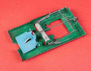 Vintage mice trap isolated on red background - concept of scam and fraud