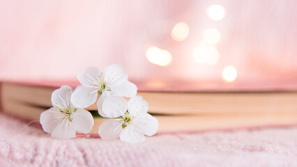  book with white small flowers on a pink background	