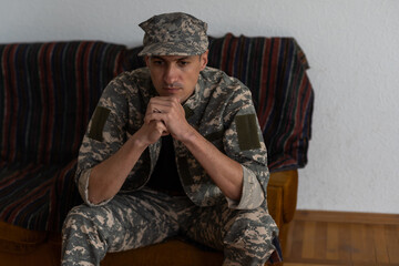 Disabled male veteran sitting and praying. He is wearing military uniform