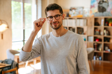 White bristle man in eyeglasses smiling while working at office