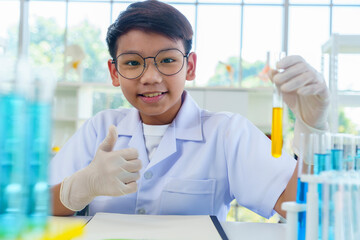 Asian boy researches blue liquid in chemistry lesson at laboratory