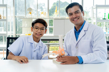 Young teacher and student boy learning anatomy of the human foot