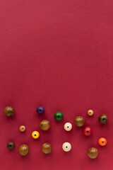 flat lay composition with decorative baubles folk beads and space for text on red background	