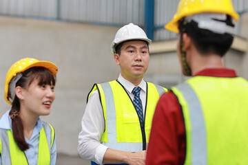 Group of asian technician engineer and businessman in protective uniform standing and discussing, researching, brainstorming and planning work together with hardhat at industry manufacturing factory