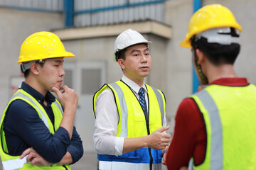 Group of asian technician engineer and businessman in protective uniform standing and discussing, researching, brainstorming and planning work together with hardhat at industry manufacturing factory