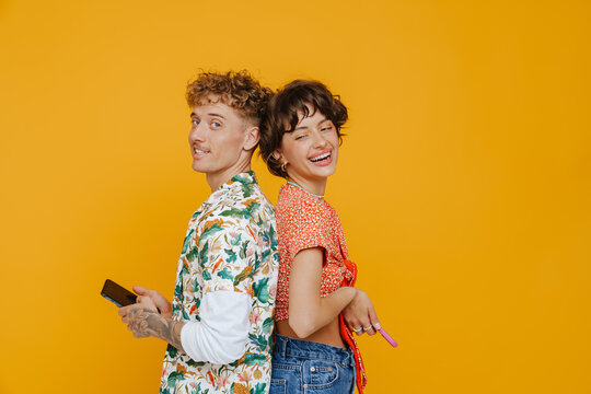 Young Smiling Man And Happy Woman Standing Back To Back