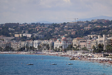 Fototapeta na wymiar View of the Promenade des Anglais and the beaches of Nice at the height of the tourist season in August