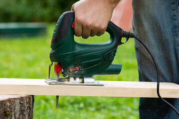 Cutting boards with an electric jigsaw outdoors.