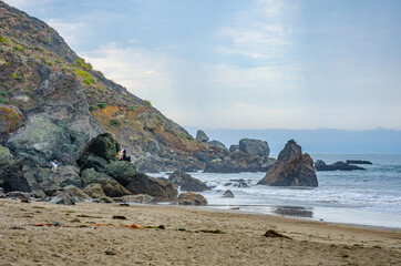Fototapeta na wymiar Rocks stretching out into the sea at the edge of Muir Beach, Marin County, California, USA