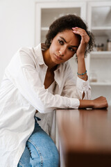 Young black woman being upset and thinking about abortion at home