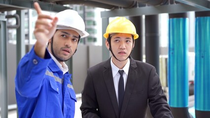 Professional Asian foreman and construction manager talking - discussing about building structure plant together.