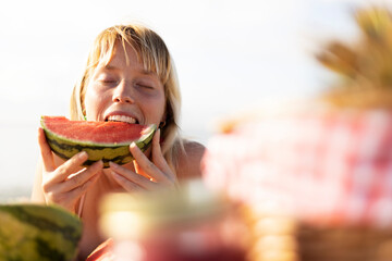 Cheerful young woman enjoy at tropical sand beach. Portrait of happy girl with fruit.