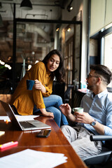 Colleagues in office. Businesswoman and businessman drinking coffee.