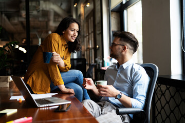 Colleagues in office. Businesswoman and businessman drinking coffee.