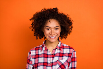 Photo of optimistic millennial brunette lady wear red shirt isolated on orange color background