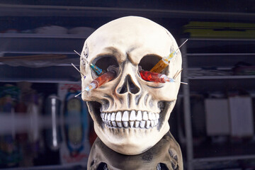 Skull with colorful syringes. Concept of drug overdose. Death caused by drugs.