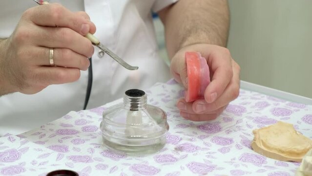 Dental technician heats the instrument for fabricating removable dentures
