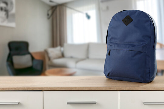 School backpack on an empty table in a sunny living room