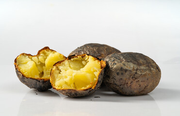 Fresh baked potatoes on a plain white background