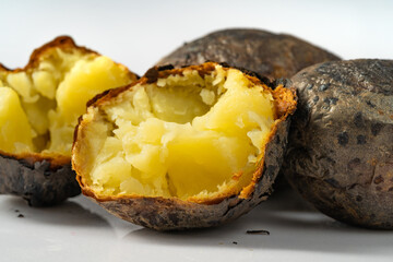 Fresh baked potatoes on a plain white background