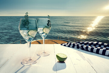 Glasses with fresh lemonade, cocktail with cucumber on deck of luxury cruise ship during honeymoon...