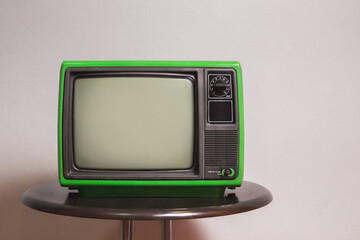 Old green TV on round table in the living room