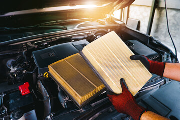 The mechanic holds a new car air filter to replace the old car filter, Automobile maintenance service business concept