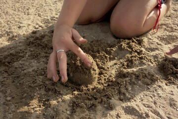 child hands and feet in the sand makes among us
