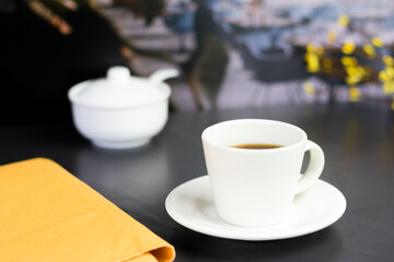 international coffee day, traditional colombian drink, close-up of coffee mug on the black table in the restaurant