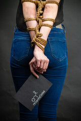 Vertical shot of bound girl holds paper with methamphetamine molecule. Drug addiction and...