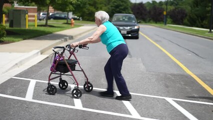 Elderly senior woman pushing a walker at pedestrian crossing with stop sign outside for exercise and mobility.