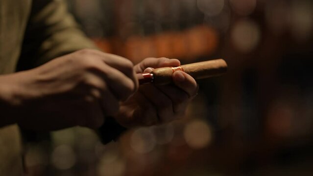Night club concept of 4k Resolution. Close-up of the hand of an Asian man cutting a cigar in a restaurant.