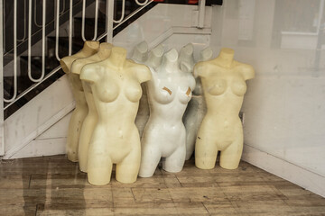 a group of incomplete mannequins in a shop window