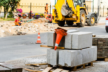 Construction of a road on a city street. Granite curbs and traffic cones at a construction site....