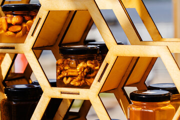 Honey with nuts in glass jars. Trade in useful farm products. selective focus