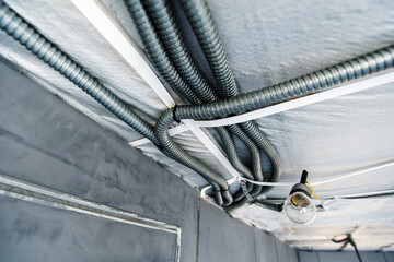 Installation of electrical wiring on the ceiling in a metal corrugation. selective focus